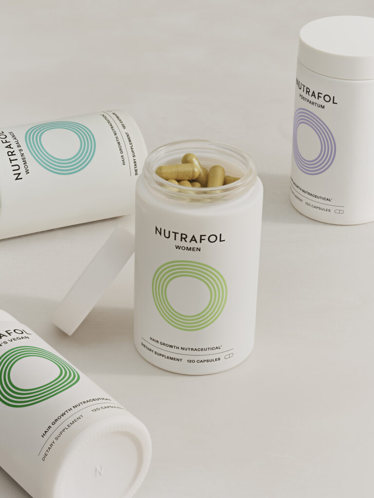 Nutrafol Women’s Hair Growth Supplements in white bottles with colored rings, including open and closed containers of Nutrafol Women, Women’s Balance, Postpartum, and Women’s Vegan formulations, displayed on a neutral background.