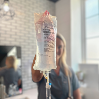 Person holding an IV therapy bag at New You Health, showcasing hydration wellness treatments available in Peoria, IL.